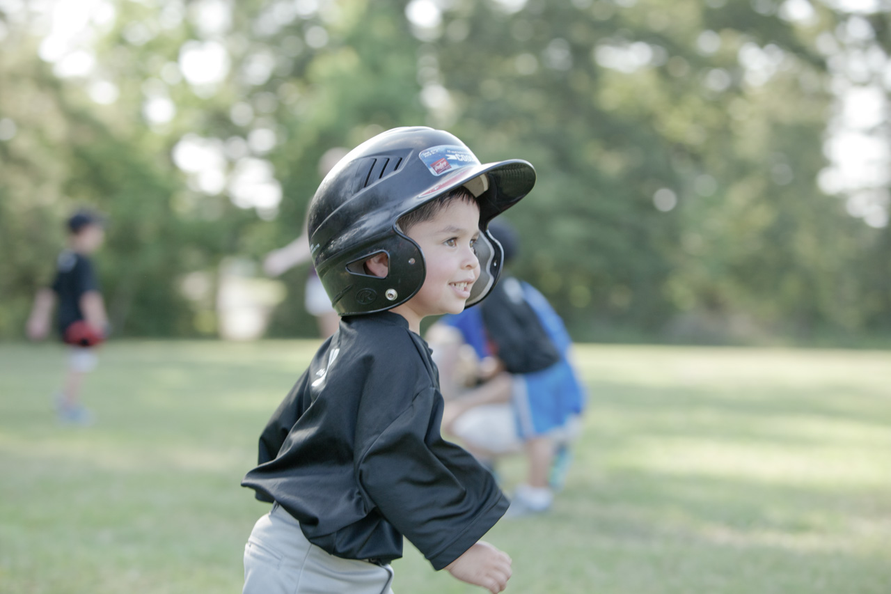 A profile view of a young boy in a baseball helmet