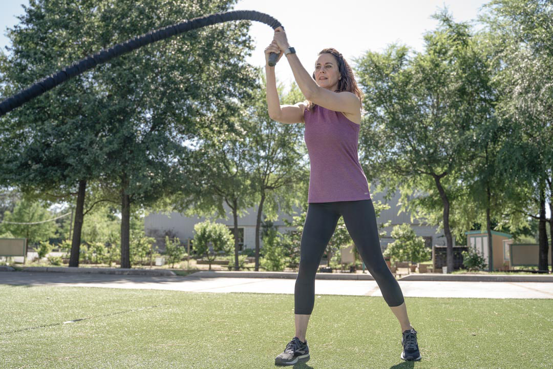 A woman uses a battle rope outdoors